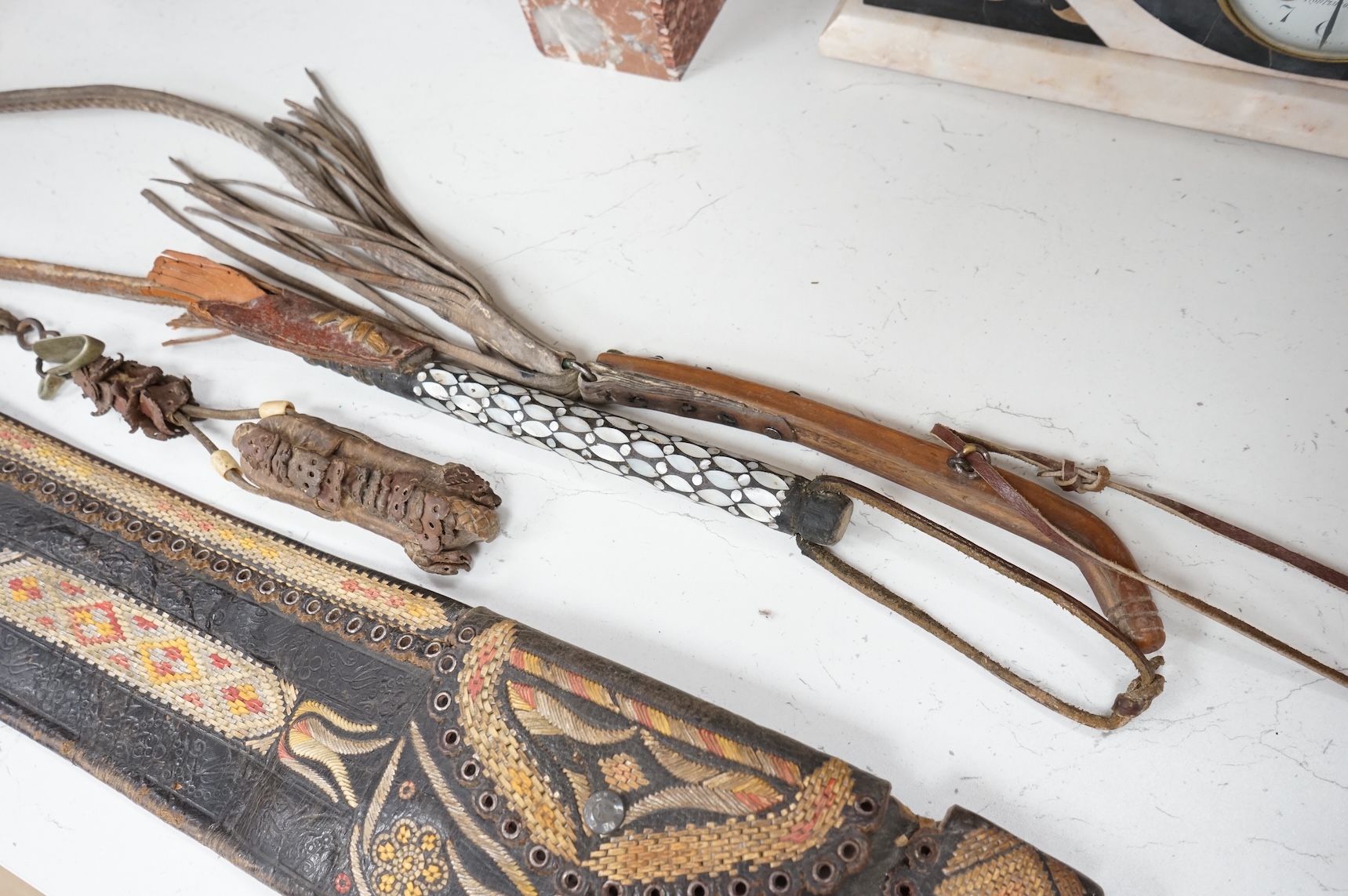 An Argentinian braided leather belt and whips, one with mother of pearl inlay